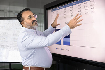 Serious senior Indian business project leader man giving seminar