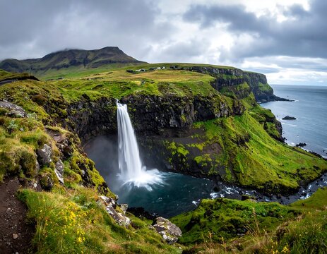 Dramatic waterfall cascades into ocean, surrounded by green cliffs - Powered by Adobe
