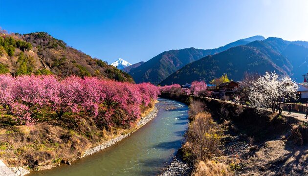 Vibrant Spring River Valley with Snow-Capped Peak