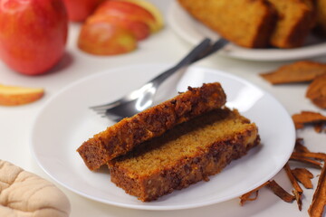 Slices of moist apple cinnamon bread on a white plate with a fork