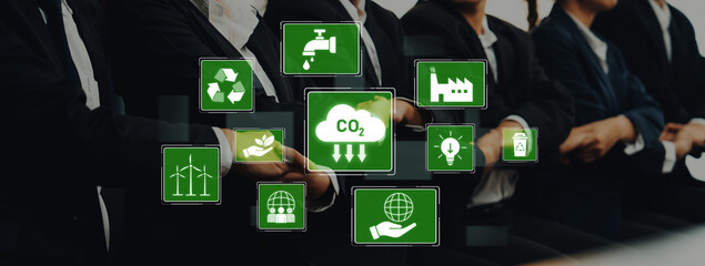 A professional group engages in sustainability discussions while digital icons illustrate key environmental topics such as CO2 reduction, recycling, and renewable energy. Trope