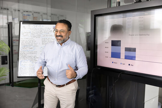 Happy mature Indian executive man presenting project analytic data
