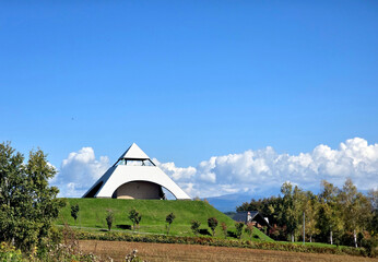 This striking structure is nestled in a serene landscape, showcasing a blend of nature and contemporary architecture