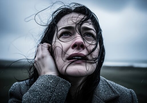 Cinematic portrait of a desperate woman looking up in the heavy rain and wind