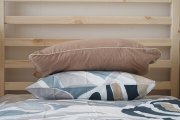 Cozy bed with stylish pillows in a simple room