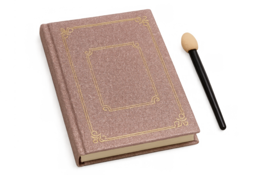 Vintage pink book or journal with ornate gold detail next to cosmetic applicator on transparent background