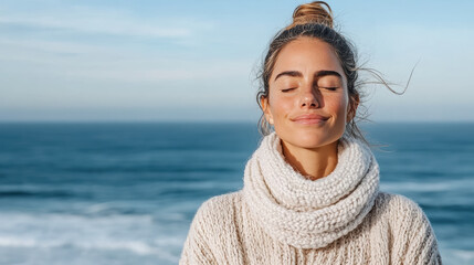 Young woman with closed eyes breathing ocean air, relaxed by sea