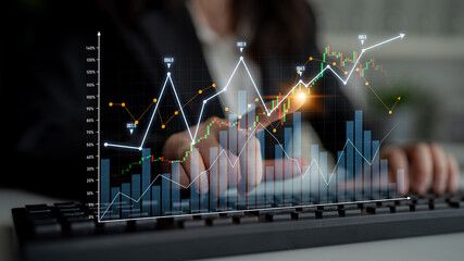 A business professional engages in data analysis on a keyboard, focusing on digital graphs that represent financial trends and performance metrics in a modern workspace. Scalp