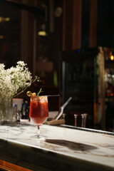 Bloody Mary cocktail garnished with olive, baby corn, and rosemary