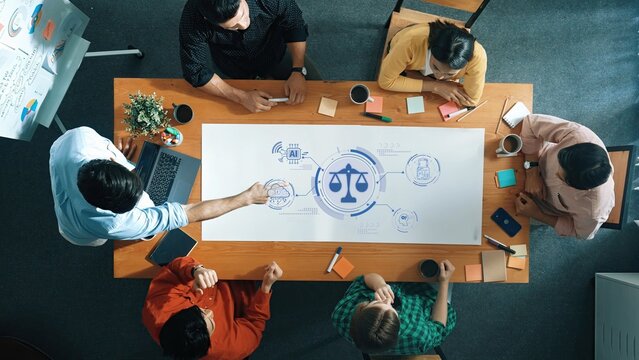 A diverse group engaged in an important discussion about ethical implications of technology, collaborating over data and visual aids in a modern office environment. Raster