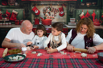 Family baking christmas cookies together in festive kitchen