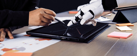 A human and a robot collaborate in a modern office environment, interacting with a tablet. Colorful notes and sketches enhance the creative atmosphere of teamwork.Noogenesis