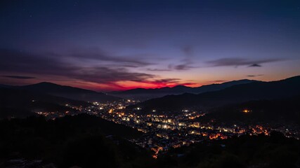Serene cityscape transitions from sunset to night, featuring majestic mountains, valley, and dynamic time lapse sequence capturing urban landscapes transformation, perfect for visual.
