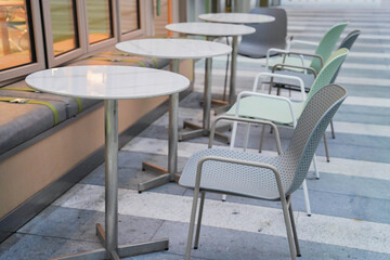 Empty steel chair and tables outside restaurant or care along street