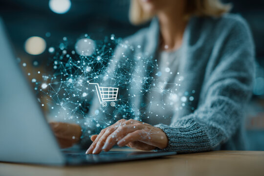 Young businesswoman using laptop and tablet with digital shopping icons in modern office