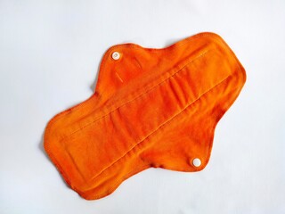 orange reusable menstrual cloth pad on a white background