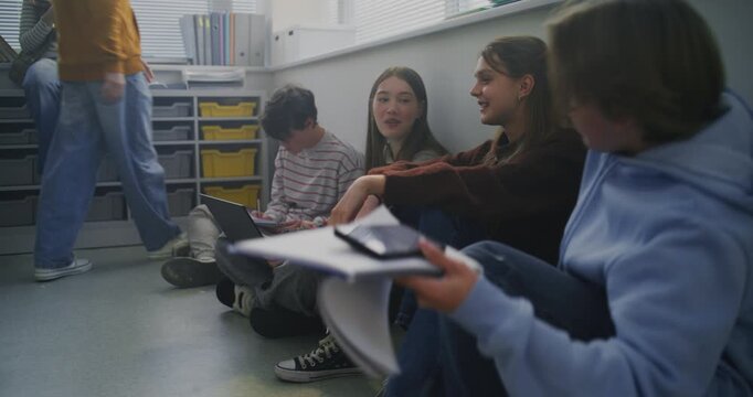 Students Sit Together on Floor Around Laptop, Sharing Ideas and Writing Notes During Collaborative Study Session. Concept Peer Learning, Open Dialogue, and Flexible Modern Classroom Environment.