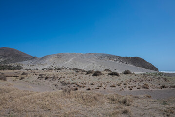 The fossil dune of Monsul in Almeria, Spain. This unique geological formation, shaped by wind and time, stands by the Mediterranean, offering a striking contrast between arid land and the blue sky