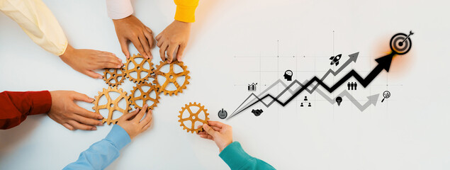 Obraz premium Diverse hands reach for gears symbolizing teamwork and collaboration, while a business growth graph illustrates progress and success in a modern workspace. Trope