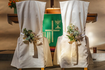 Zwei weiße Stühle, gehüllt in fließenden, seidenen Stoff, stehen bereit. Sie sind nicht nur Sitzgelegenheiten, sondern Symbole der gemeinsamen Zukunft.