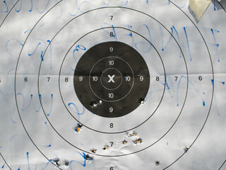 Old practice shooting target, damaged gun, bullet traces	
