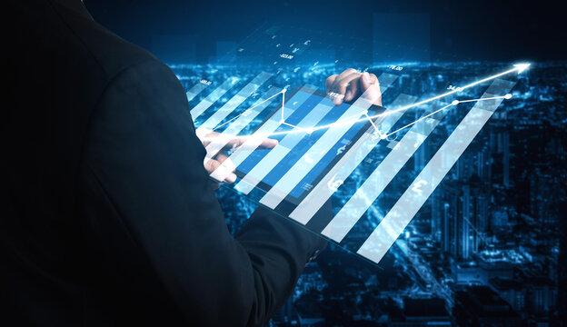 A business professional engages with digital graphs and charts showcasing financial data trends against a vibrant urban skyline at night. Impute - Powered by Adobe