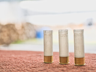 Shotgun shells on a red background at a shooting range © saksuvan