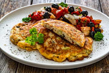 Vegetable pancakes with fresh salad on wooden table