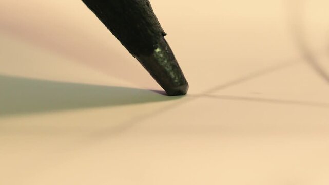 An extreme macro shot showing a pencil tip in motion, emphasizing the texture of the graphite and paper, suggesting intense focus and the start of a creative process