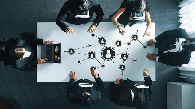 Professionals Engaged in Networking Session with Virtual Reality Technology Enhancements and Collaborative Discussion at Modern Office Table. Amity