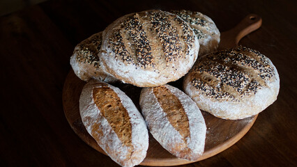 Artisan seeded bread loaves on wooden board, rustic bakery still life