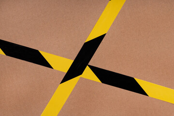 Black and yellow striped сaution tape on cardboard background. prohibitory warning tape packaging...