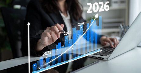 A business professional examines a financial growth chart on their laptop, predicting trends from 2023 to 2026 in a stylish office environment. Tessel
