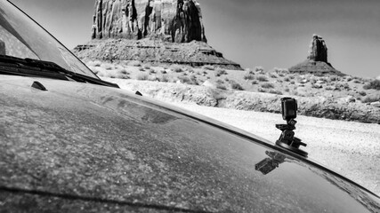 Action camera mounted on a car capturing scenic drive through Monument Valley desert landscape