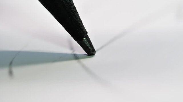 An extreme macro shot showing a pencil tip in motion, emphasizing the texture of the graphite and paper, suggesting intense focus and the start of a creative process