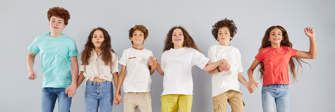 Active funny group children portrait of young happy diverse school pupils, students, teens, team friends close together jump, education community, creative teen club meeting fun, spirit, teambuilding 