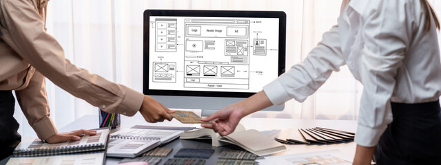 Group of interior architect designer team at table choosing various mood board samples with architecture software on laptop screen. Modern renovation and interior material selection concept. Insight