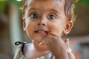 Cute Little Girl with Big Expressive Eyes Giving a Playful Look in a Natural Outdoor Setting