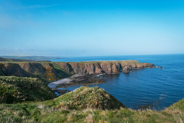 Scenic green coastal cliffs and rocky bay