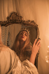 Obraz premium Queen in the Mirror. Emotional vintage warm portrait with candles around 