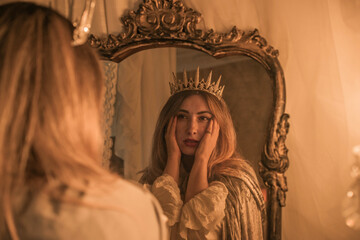 Queen in the Mirror. Emotional vintage warm portrait with candles around 