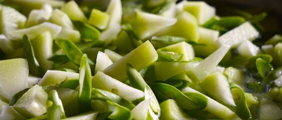 Close-up of chopped green onions in a bowl, ready for cooking.