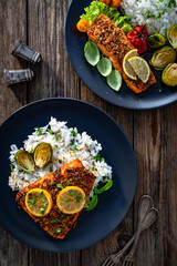 Baked salmon with white rice on wooden table. Top view