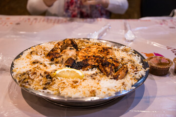 Arabian biryani dish with rice and chicken served on a traditional platter