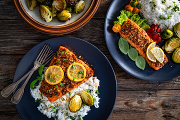 Baked salmon with white rice on wooden table. Top view