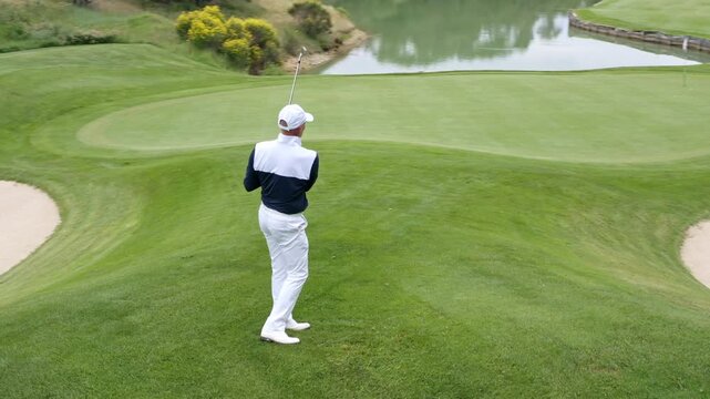 Golfer swings club in beautiful green landscape during afternoon round