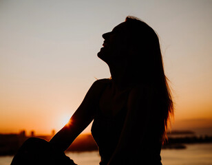 soft  silhouette  of a person laughing at sunrise.  soft diffused lighting.