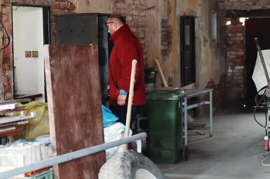 Man Bringing a Fully Loaded Pallet Truck into a Broken, Overfilled Old Workshop Packed with Discarded Items as Part of a Large‑Scale Clearance After Decline, Collapse, and the Beginning of a Full Rest