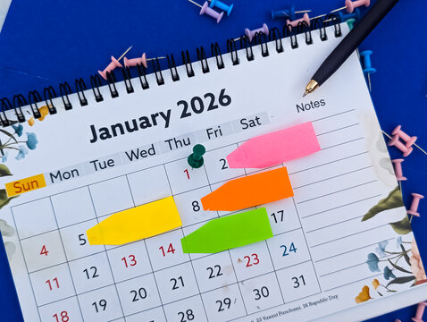 sticky notes and push pins on january 2026 calendar for planning, reminders and organization, new year concept