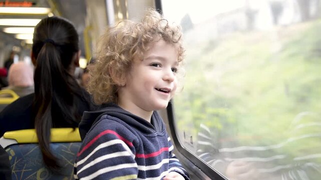 Happy and excited young boy travelling on a metro train; Melbourne, Victoria, Australia